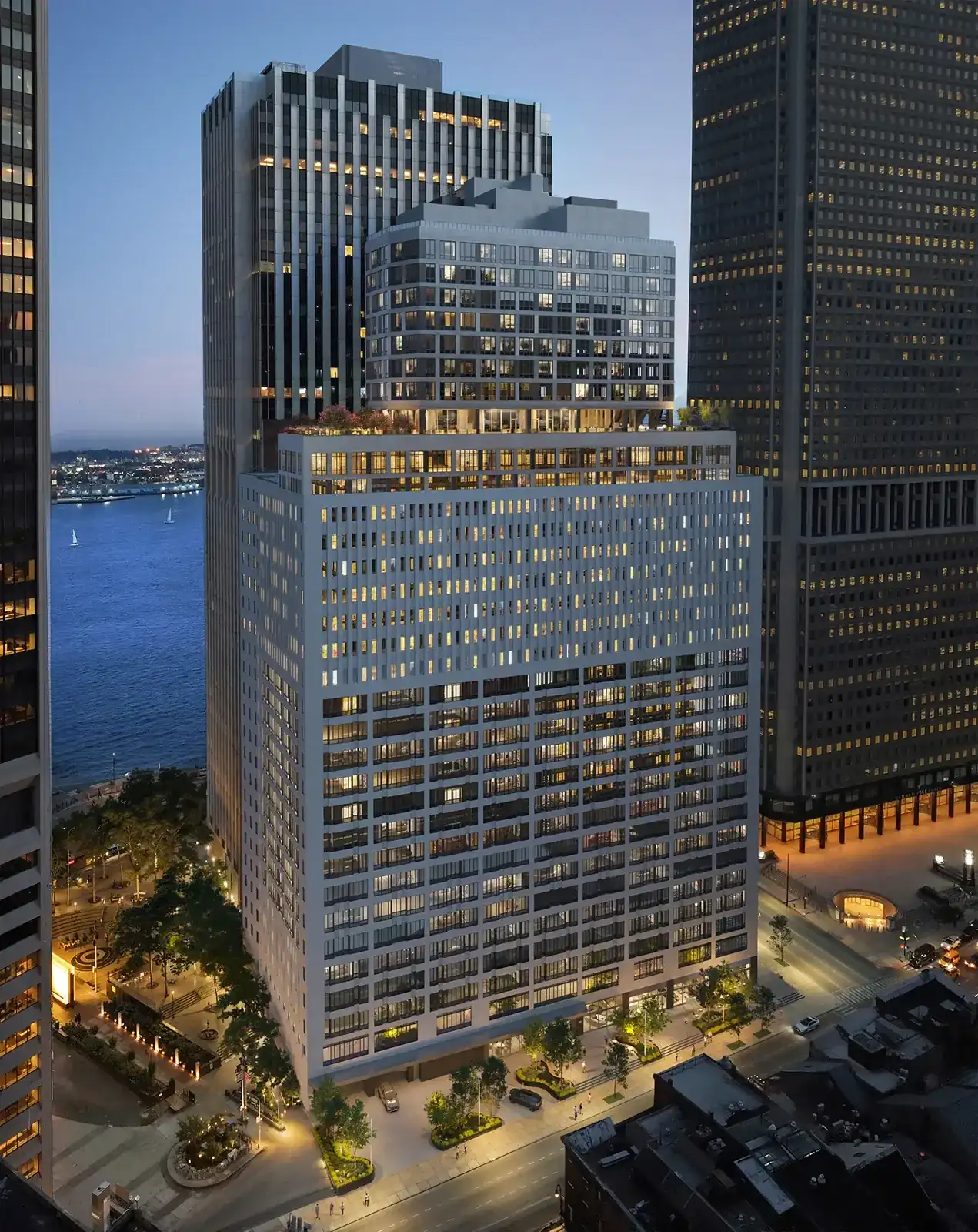 SoMA at 25 Water Street at dusk, a converted office tower in Lower Manhattan seen from above with the harbor behind it.